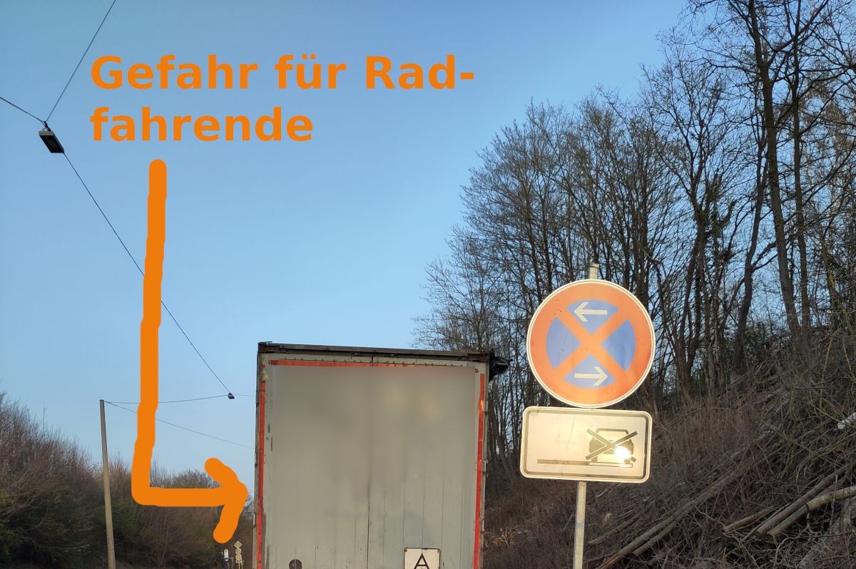 LKW-Rückseite fotografiert, parkend auf Seitenstreifen. Rechts am Rand Halteverbotsschild. Rechts davor angefahrenes Halteverbotsschild.